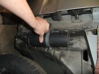 Hier halte ich den Behälter samt Halteband und dem Metallhalter an die A-Säule eines anderen 44ers. Ja! dort soll er hin. Weil vorne kein Platz mehr war, dort sind nämlich schon der Lufikasten, Ölkühler, dessen Luftführung, Bremskühlungs-luftführung UND ja der grosse Wischwasserbehälter passt auch noch ausgezeichnet. Ja genau deshalb verlege ich den Aktivkohlebehälter an die A-Säule, btw. ist dieser beim 220V auch an der A-Säule, AAAber Der behälter ist vollkommen anders geformt, es scheint, dass es für sie billiger war einen komplett neuen Plastikbehälter zu entwickeln, als ein schraubbares Blechteil für den vorhandenen Behälter. Also dachte ich mir, OK mach ichs mir lieber schwerer, wenns auch leicht geht, denn ich wette, wenn ich nach so einem 220V Aktivkohlebehälter gesucht hätte, hätte ich Wochen, Monate.... gewartet. Also Halter anfertigen und gut. Leider stimmte bei dem Metallbändchen die Position der Schraube nicht...